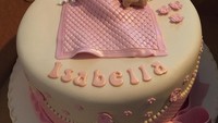 Paduan pink dan putih, menandakan anak yang akan lahir ialah anak perempuan. Kue berbentuk bulat ini diberi topping fondant bentuk bayi yang sedang terlelap bersama boneka beruangnya.  Foto: Instagram @bakemeacakeorlando