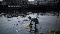 Seorang pria mencuci sayur di Sungai Buriganga yang tercemar polusi di Kota Dhaka, Bangladesh. Zakir Hossain Chowdhury/NurPhoto via Getty Images. 