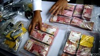 Polisi menunjukkan barang bukti uang puluhan juta rupiah.