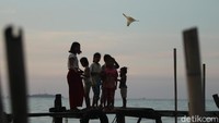 Sembari menerbangkan layang-layang mereka juga harus menjaga kesimbangan.
