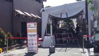 Di jalan menuju rumah duka, aparat memasang banner bertuliskan daerah terbatas. Pelayat dilarang memotret dan membawa barang-barang berbahaya.