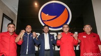 Hasto Kristiyanto dan Johnny G Plate saling bergandengan tangan.