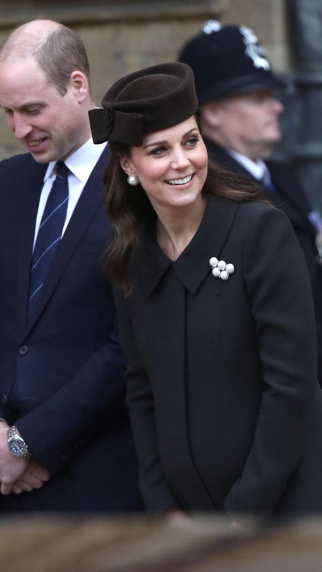 Juga hadir dalam balutan busana serba hitam, Kate Middleton. Istri Pangeran William yang tengah menantikan kelahiran anak ketiga itu mempercantik gaun bersiluet coat-nya dengan bros mutiara. Tidak ketinggalan topi yang dipermanis dengan aksen pita berukuran besar. (Foto: Getty Images)