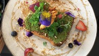 Toast dengan olesan matcha inipun tak klah cantik. Dikucuri sirop maple dengan taburan buah dan bunga warna-warni. Foto: Instagram @cafelafayette