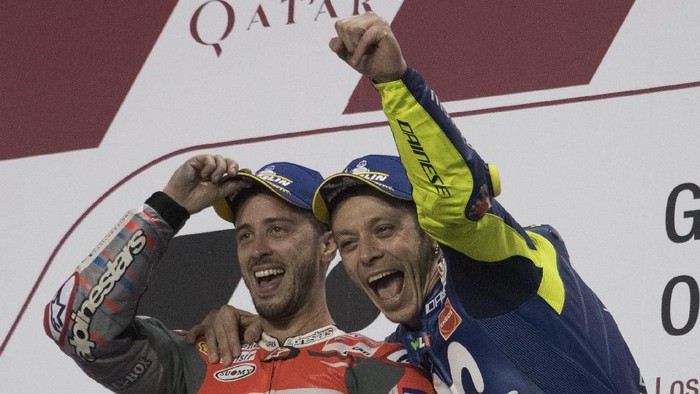 DOHA, QATAR - MARCH 18:  Valentino Rossi of Italy and Movistar Yamaha MotoGP smile with Andrea Dovizioso of Italy and Ducati Team (L) on the podium at the end of the MotoGP race during the MotoGP of Qatar - Race at Losail Circuit on March 18, 2018 in Doha, Qatar.  (Photo by Mirco Lazzari gp/Getty Images)