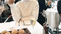Mengenakan outfit warna putih, Kimmy menikmati segelas champagne ditemani beberapa potong roti.  Foto: Instagram @kimmyjayanti