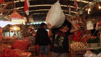 Seorang kuli angkut sedang mengantarkan barang.