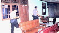 Anjing pelacak dipandu oleh seorang anggota Polri.