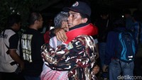 Dua orang warga yang diduga kerabat korban berpelukan di depan rumah yang menjadi lokasi penyanderaan.
