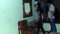 Polisi memeriksa jendela rumah yang telah pecah.