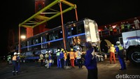 Satu per satu gerbong kereta diturunkan dari atas kapal kargo.