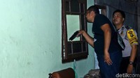 Polisi memeriksa jendela yang telah pecah.