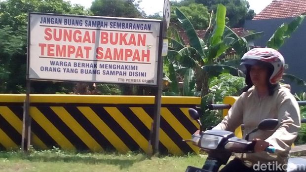 Papan 'Pembuang sampah boleh dihakimi warga' sebelum diganti.