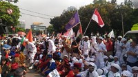 Demo diawali dengan kumandang azan. Setelah melantunkan azan, orator membacakan ayat-ayat suci Alquran. Selanjutnya, orator bersama massa menyanyikan lagu Indonesia Raya. (Foto: Samsudhuha Wildansyah/detikcom)