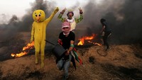 Warga Palestina mengenakan kostum karakter burung dalam bentrokan tersebut. Foto: REUTERS/Ibraheem Abu Mustafa