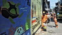 Sejumlah pasukan oranye mengecat di beberapa rumah di Kelurahan Sunter Jaya, Jakarta Utara, Jumat (6/4).