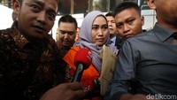 Tampak murung, Tri Yudiana yang telah resmi menggunakan rompi tahanan KPK.