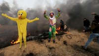 Ada pula warga yang mengenakan kostum nadut. Foto: REUTERS/Ibraheem Abu Mustafa