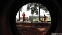 Petugas membersihkan kawasan Kanal Banjir Timur Duren Sawit, Jakarta, Kamis (5/4/2018).