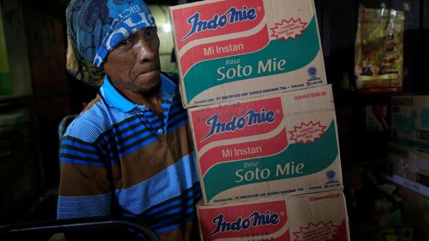 A worker holds instant noodle packs at a market in Jakarta, Indonesia, March 12, 2018. Picture taken March 12, 2018. REUTERS/Beawiharta