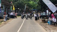 Di pinggir jalan, warga mendekat ingin melihat Jokowi dan rombongannya. Jokowi pun melambaikan tangan untuk menyapa warga.