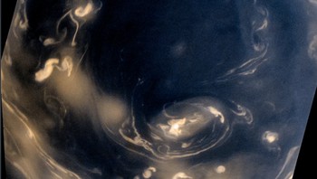 Awan yang tampak berliku-liku, berputar di pusaran kutub selatan Saturnus. Pemandangan ini terihat dari pesawat ruang angkasa Cassini NASA. Lingkaran awan yang sangat tinggi ini mengelilingi daerah gelap tempat badai konvektif berkecamuk di atmosfer Saturnus.    Ilmuwan Kevin Gill menciptakan gambar berwarna ini menggunakan data mentah dari Cassini. Ketika Cassini menangkap gambar pada 14 Juli 2008, pesawat ruang angkasa itu berada pada jarak 392.000 kilometer dari Saturnus. Foto: NASA/JPL-Caltech/SSI/Kevin M. Gill/Flickr via Space.com