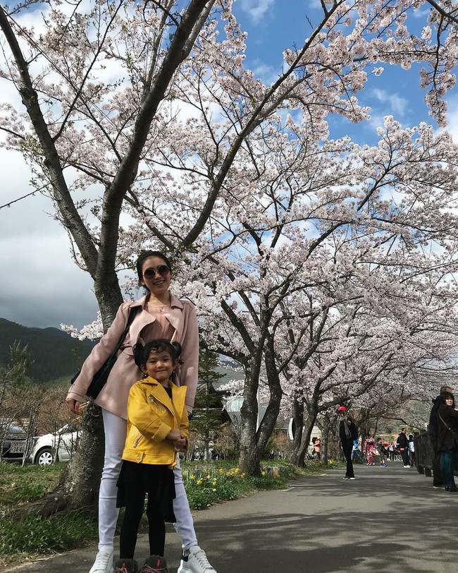 Berpose bersama putri semata wayangnya, Ayu Ting Ting bergaya menenteng tas Hermes seri Lindy saat berpose di antara bunga Sakura. Foto: Instagram