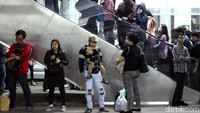 Penumpang berjejer di eskalator.