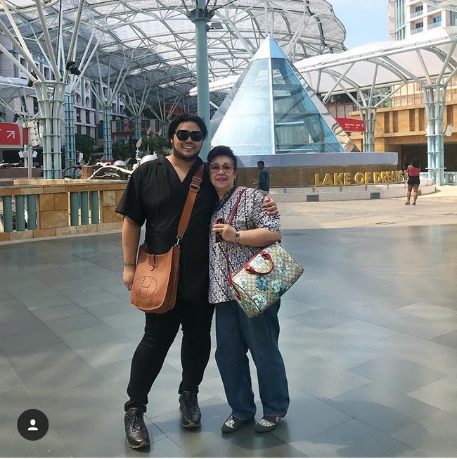 Berlibur bersama ibunda tercinta, Ivan Gunawan terlihat membawa tas Hermes GM Evelyn Cognac Togo Leather Bag NWT 32 cm yang harganya US$ 3.900 atau sekitar Rp 53,6 juta. Foto: Instagram