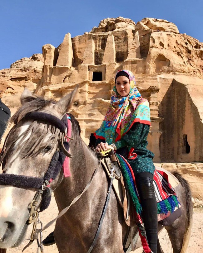 Mengunjungi tempat bersejarah tersebut, Mulan Jameela memilih knit wear hijau bernuansa glitter. Ia padukan busananya dengan hijab segi empat yang bermotif khas etnik Timur Tengah. Foto: Instagram/MulanJameela1