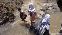 Bahaya besar selalu menanti para siswa. Namun, kondisi tersebut tak menyurutkan semangat belajar siswa SDN 2 Patapan tersebut. Derasnya arus sungai serta terjalnya bebatuan membuat siswa kesulitan menyeberang. (Foto: Sudirman Wamad/detikcom).