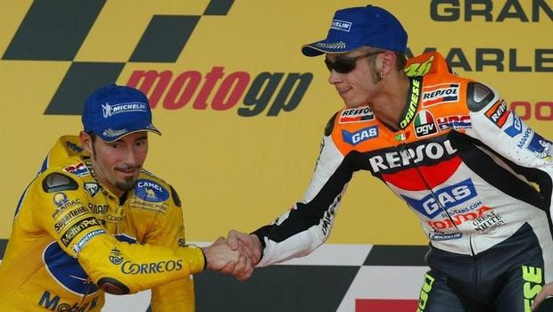 Moto GP World Champion and winner of the Moto Grand Prix of Spain, Italian Valentino Rossi (R) shakes hands with his fellow compatriot and second placed Max Biaggi on the podium 11 May 2003, in Jerez. Australian Troy Bayliss finished third. AFP PHOTO/ Pierre-Philippe MARCOU / AFP PHOTO / PIERRE-PHILIPPE MARCOU
