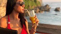 Wah, Melly sadar banget nih kalau pemandangan di belakangnya keren. Pose minum jus pun jadi Instagramable berkat cantiknya pantai di Bali. Foto: Instagram melly.bradley