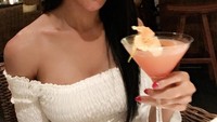 Masih di Bali, Melly bersantap minum cocktail di bar. Ia sudah menjalani operasi penggantian kelamin dan implan payudara sehingga fisiknya menyerupai wanita tulen. Foto: Instagram melly.bradley