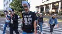 Mereka menggunakan topeng wajah Novel dan membagikan selebaran soal perjalanan kasus Novel sambil naik Bus TransJakarta.