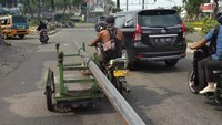 Simalakama ini ceritanya. Mau didahulukan jalannya lambat, mau dipotong jalannya terhalang oleh bawaannya. Membawa batangan besi panjang menggunakan becak barang, pemotor ini malah membahayakan pengguna jalan lainnya. Foto diambil dijalan Simpang Selayang Medan. Foto: pasangmata.com (https://pasangmata.detik.com/contribution/311194)