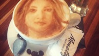 Suka ngopi, Dena memesan segelas latte panas nih. Uniknya, latte art dibuat mirip wajahnya. Keren! Foto: instagram @denarachman
