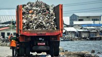 Setelah diangkut perahu, sampah itu kemudian dipindahkan ke truk.