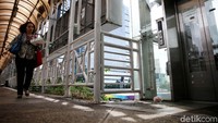 Seorang warga melintas diantara lift khusus disabilitas yang rusak.
