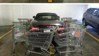 Kesal karena parkirnya sembarangan, mobil ini dikelilingi troli. Foto: Turbo ROTFL
