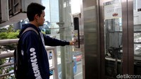 Seorang warga terlihat menekan tombol lift yang sudah rusak.