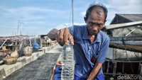 Seorang warga memperlihatkan air bersih yang diisi ke dalam botol.