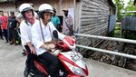 Foto: Jokowi-Iriana Boncengan Motor Menembus Hujan di Asmat