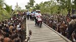 Foto: Jokowi-Iriana Boncengan Motor Menembus Hujan di Asmat