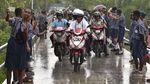 Foto: Jokowi-Iriana Boncengan Motor Menembus Hujan di Asmat