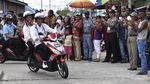 Foto: Jokowi-Iriana Boncengan Motor Menembus Hujan di Asmat