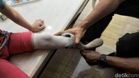 Petugas membantu memasangkan kaki palsu.