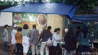 Kedai es Milo kepal ini terbilang sederhana. Hanya bermodal meja panjang dan beratap terpal. Tapi pembeli yang antre sampai mengular. Foto: Devi S. Lestari / detikFood