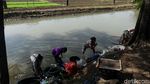 Mencuci Pakaian di Sungai Keruh