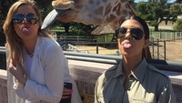 Ini gaya gokilnya bersama Kourtney Kardashian saat berpose bersama Jerapah. Lucu! (khloekardashian/Instagram)